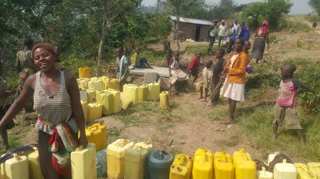 De lokale gemeenschap haalt water bij een aangelegde pomp